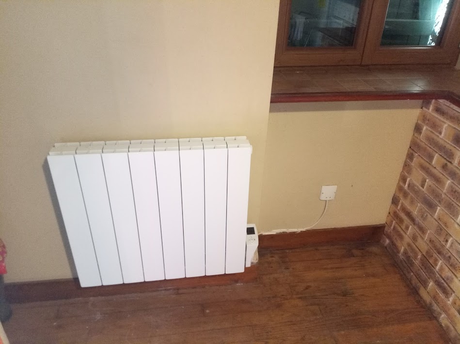 Radiateur électrique à inertie posé sous une fenêtre