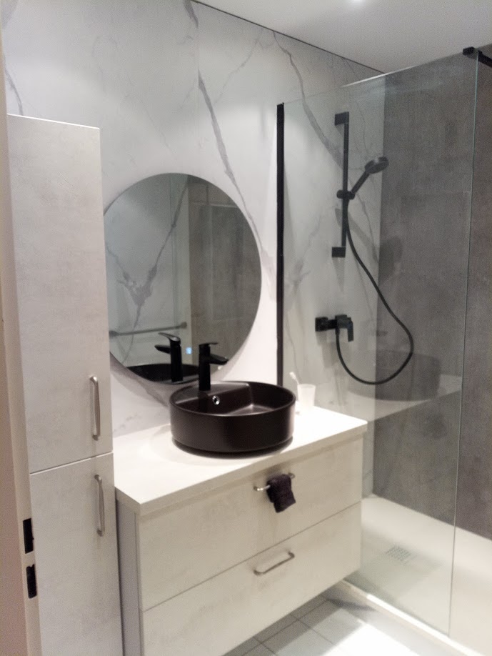 Salle de bain moderne — vasque noire ronde, miroir rond et douche à l'italienne