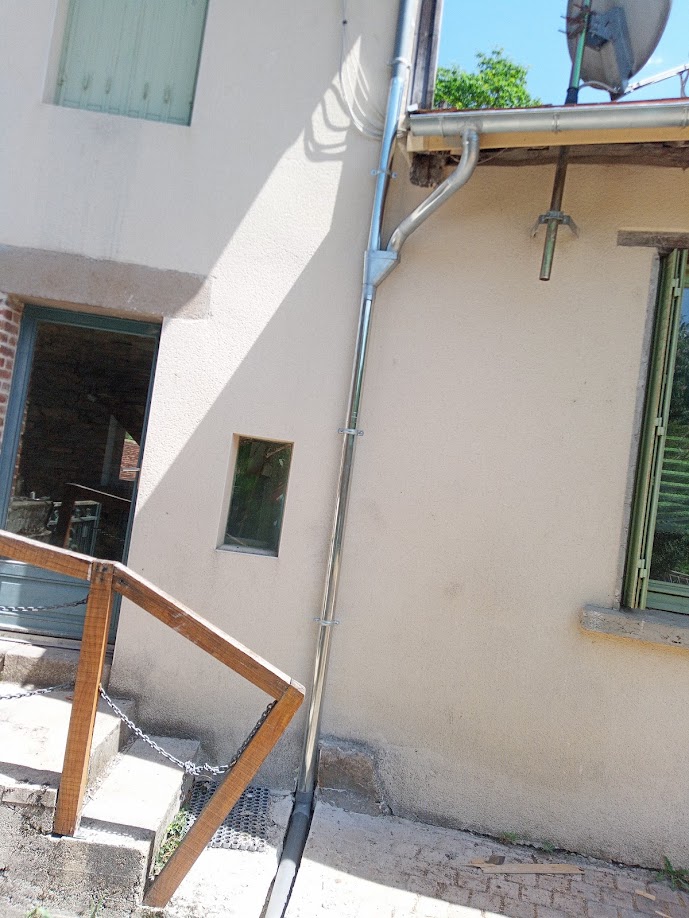 Descente de gouttière en zinc posée le long d'une façade