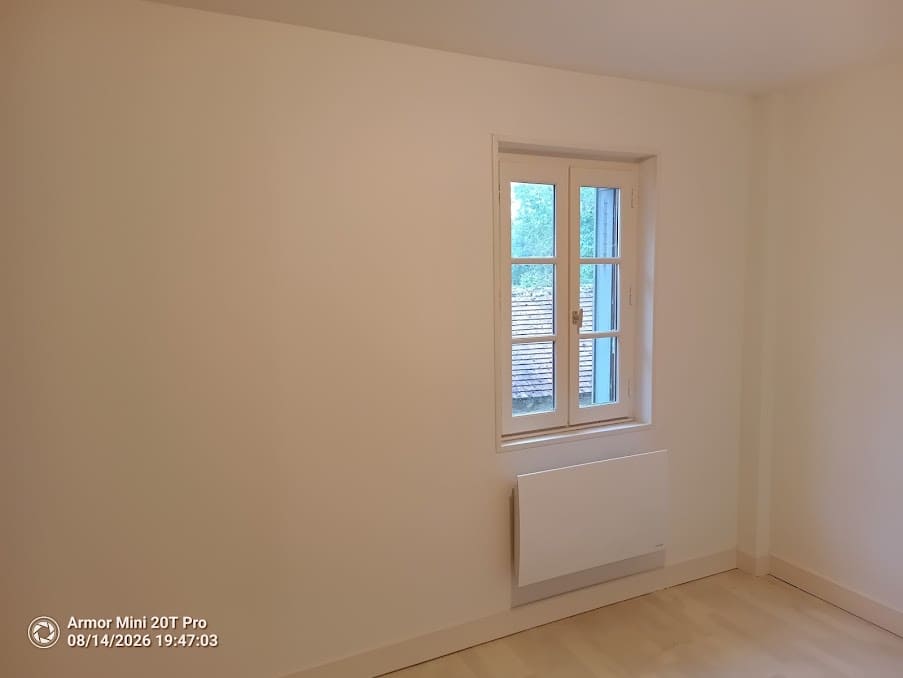 Chambre repeinte avec fenêtre bois et radiateur électrique