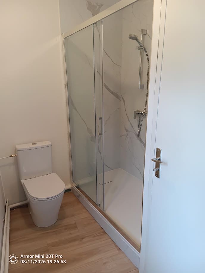 Salle d'eau terminée — WC et cabine de douche sur sol stratifié